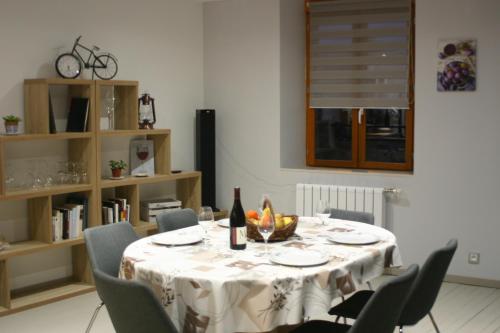 墨丘利Gîte Le Balthazar的餐桌、白色桌布和椅子