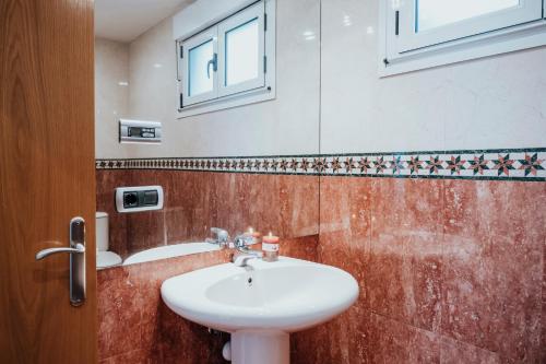 希洪EL SEXTO DE LA PLAYA + PARKING GRATIS的一间带水槽和窗户的浴室