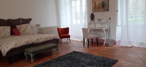 Bauné布里昂松城堡住宿加早餐旅馆的卧室配有一张床和一张桌子及椅子