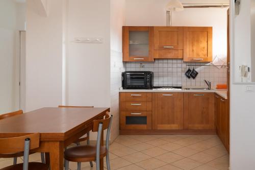 托里塔迪谢纳Casa in Chiana的厨房配有木制橱柜和桌椅