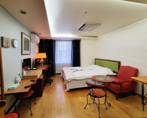 首尔克汉公寓的酒店客房,配有一张床、一张桌子和椅子