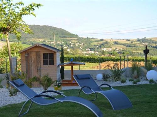 圣佩赖心藤旅馆的草地上有两个蓝色长椅的院子