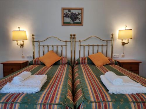 卡莫纳Entretorres. Casa-dúplex en centro histórico.的一间卧室配有两张带枕头的床。