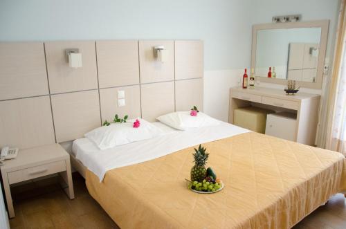 奈德里阿索斯酒店的一间卧室,配有一张床,上面放着一碗水果