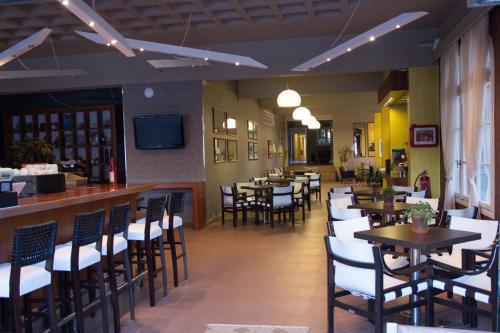 奈德里阿索斯酒店的一间带桌椅的餐厅和一间酒吧