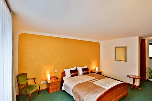 博斯克古林瓦尔泽餐厅酒店的配有一张床和一把椅子的酒店客房