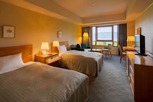小坂十和田酒店 的酒店客房设有两张床和电视。