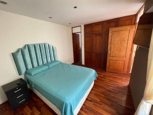 特鲁希略Exclusivo Apartamento en el corazón de Trujillo的一间卧室配有一张蓝色床头板的床