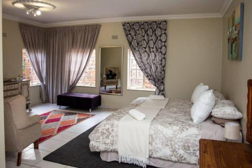 伯诺尼Ailani Grey的一间卧室配有一张床、一把椅子和窗户。