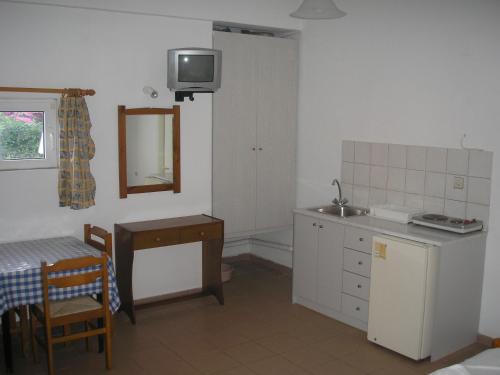 古瓦伊Dimitra Apartments的厨房配有水槽、桌子和镜子
