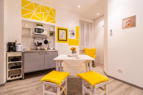 米兰Lemon Suite - Fiera Milano - City Life的一间厨房,里面配有桌子和黄色椅子