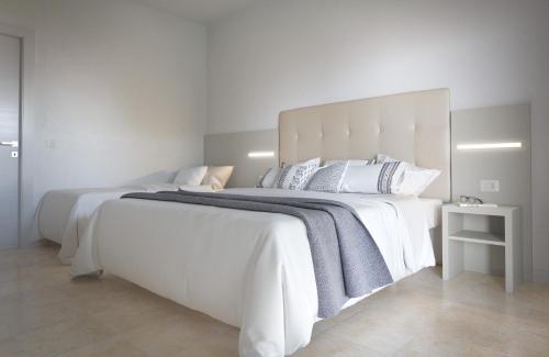 里米尼Hotel Aron的一张白色大床,配有白色床单和枕头