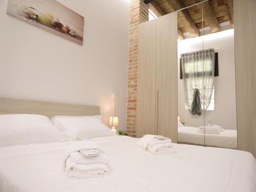 帕多瓦PRATO DELLA VALLE STUDIO的卧室配有白色床和毛巾