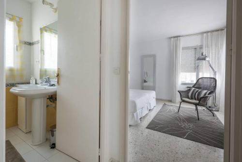 马贝拉Villa Mimosa的一间卧室配有一张床、一把椅子和一个水槽