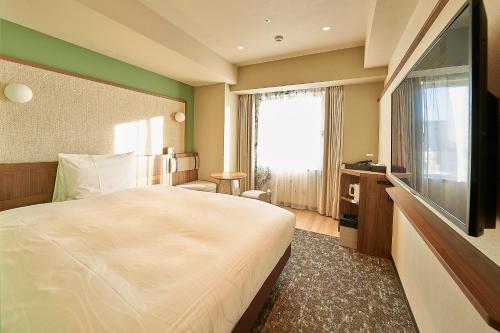东京Keisei Richmond Hotel Tokyo Kinshicho的配有一张床和一台平面电视的酒店客房