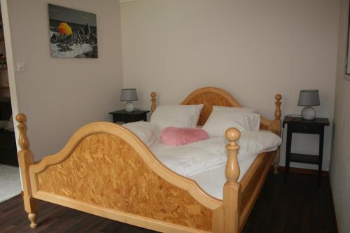 Im FangBnB Le Loft Im Fang的一间卧室配有一张木床,上面有粉红色枕头