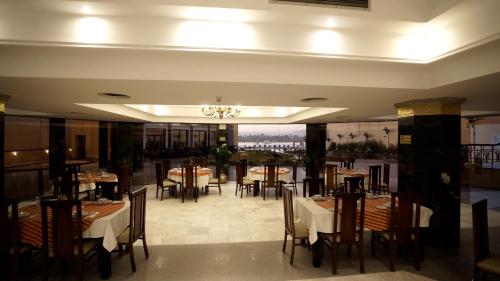 卢克索莲花卢克索酒店的一间带桌椅和吊灯的餐厅