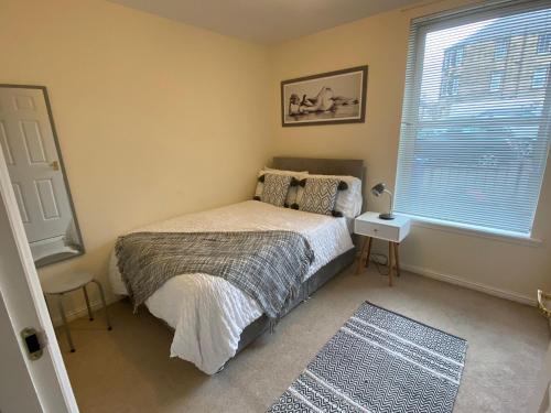 柯科迪Maltings Apartment - Spacious 2 Bed Ground Floor Apartment的一间卧室设有一张床和一个窗口