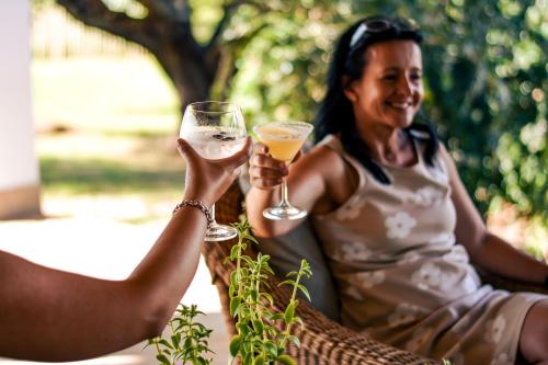 SteytlervilleRoyal Karoo Safari Lodge的一位拿着一杯白葡萄酒的女人