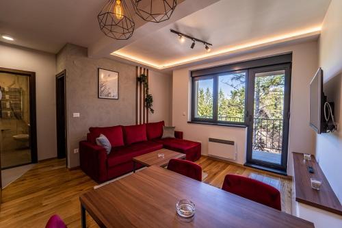 兹拉蒂博尔Titova Vila Zlatibor的客厅配有红色的沙发和桌子
