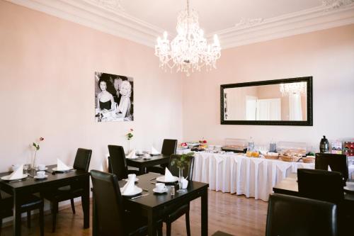 杜塞尔多夫Boutique Hotel Villa Oberkassel的一间带桌椅和吊灯的用餐室