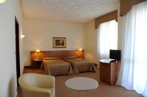 阿巴诺泰尔梅呃米塔贝莱尔医疗酒店的酒店客房设有两张床和一张桌子。
