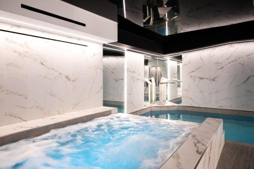 采尔马特Boutique Hotel Albana Real - Restaurants & Spa的设有带按摩浴缸和大理石墙壁的浴室
