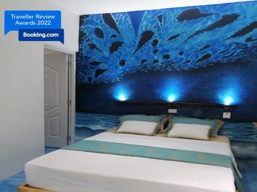 拉斯特拉纳斯贾尔丁德尔加勒比公寓式酒店的一间卧室配有一张蓝色墙壁的床