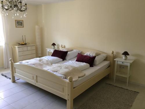 巴拉通马里亚弗都Villa Ida的卧室配有带红色枕头的白色床