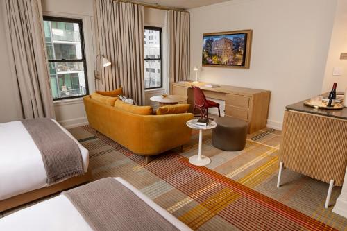 西雅图Hotel Andra Seattle MGallery Hotel Collection的酒店客房配有一张床、一张沙发和一张书桌。