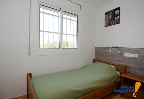 罗达德瓦拉Coral的一间卧室设有一张绿色的床和一个窗户。