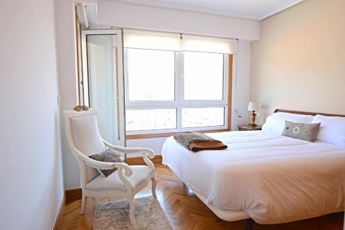 圣塞瓦斯蒂安Go Donosti Villa Berio的卧室配有床、椅子和窗户。