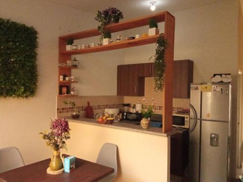 松索纳特La Casa Del Pinito的厨房配有冰箱和带鲜花的桌子