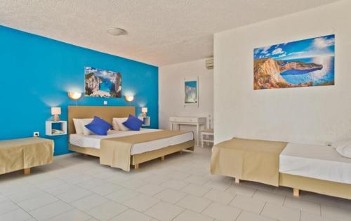 卡尔帕索斯Bluu Bahari Hotel的一间卧室设有两张床和蓝色的墙壁