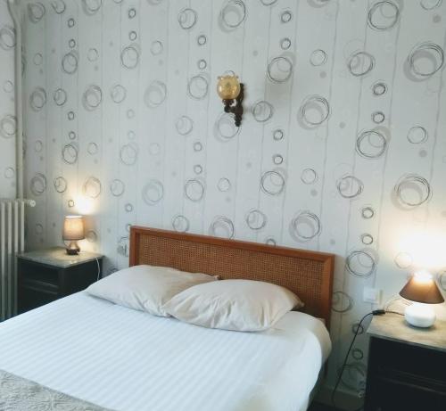 维穆蒂尔斯Le Soleil D'or的一间卧室配有一张带两张桌子和两盏灯的床。