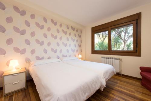 库列雷多Casa de Sabela的卧室配有白色的床和窗户。