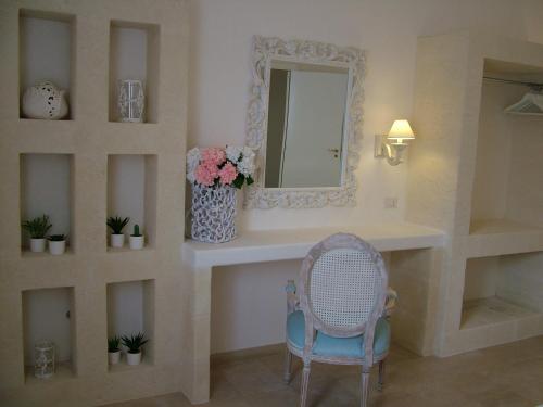 奥斯图尼Masseria Cappuccini的浴室设有梳妆台、镜子和椅子