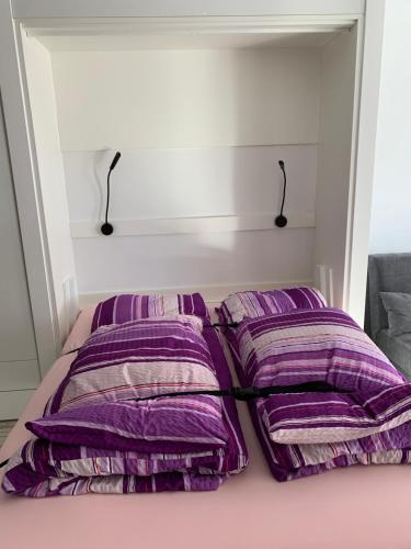 洛伊克巴德Holiday 88的床上铺有紫色枕头的床