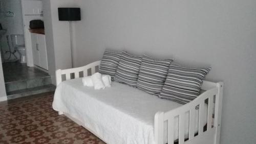 梅塞德斯Apartamento-Loft的一张白色的床,上面有两个枕头