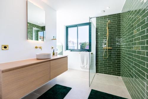 比亚里茨VILLA BIBI CHERI Elégante Suite de 35 M2的浴室设有水槽和绿色瓷砖淋浴。