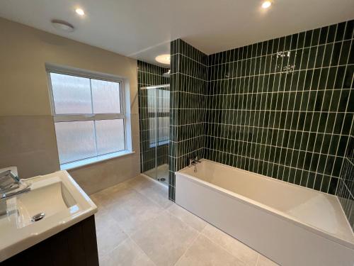 克罗默Luxury Cromer cottage with hot tub & log burner in Town的带浴缸、水槽和浴缸的浴室