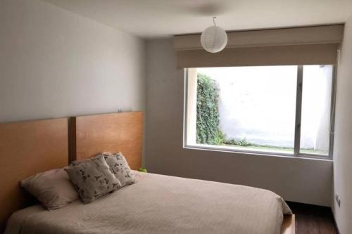 基多1430 Luxury Suite Edificio Avadell- Bellavista-Quito的一间卧室设有一张大床和大窗户