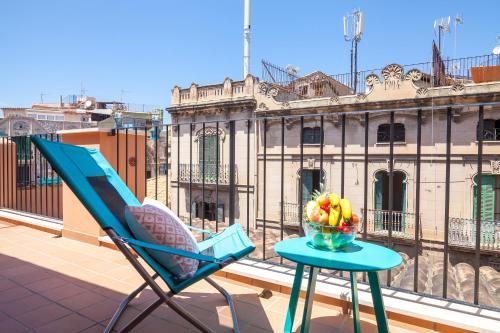 马略卡岛帕尔马坎博思图里斯莫因特廖尔公寓的阳台上的桌子上摆着一把椅子和一碗水果