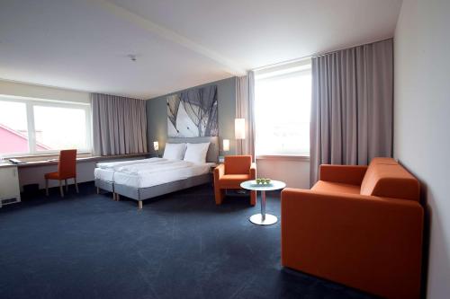 不来梅港Nordsee Hotel City的酒店客房带一张床、一张桌子和椅子