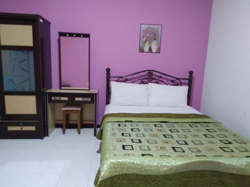 瓜埠CAMELIA HOLIDAY APARTMENT的紫色卧室配有一张床和镜子