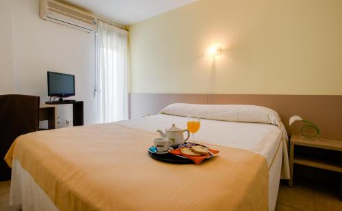 洛尔卡费利克斯酒店 的酒店客房,配有一张带食品和饮料托盘的床
