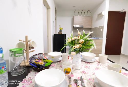 新山Parc Regency Green Homestay By Easyhomestay的厨房配有带盘子和鲜花的桌子