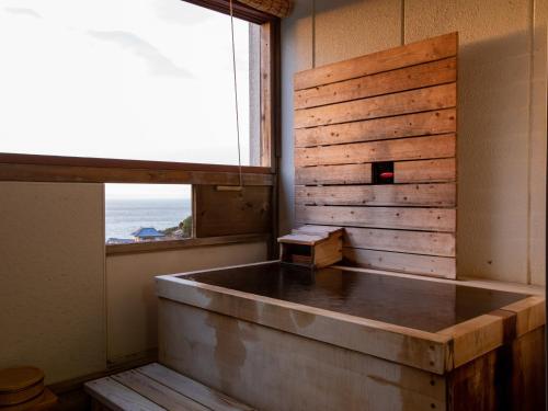 白滨特卡酷凯泰酒店的客房设有带窗户的浴缸。