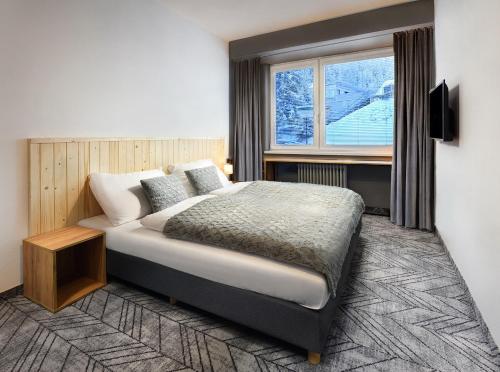 迪马诺卡多林纳思琪酒店的一间卧室设有一张大床和一个窗户。