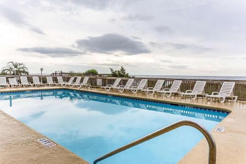 默特尔比奇Ocean Star Hotel的一个带躺椅的游泳池和海洋